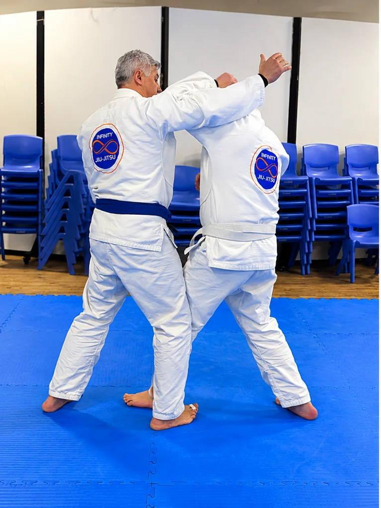 Two adult students drilling a guard position during an Adults class