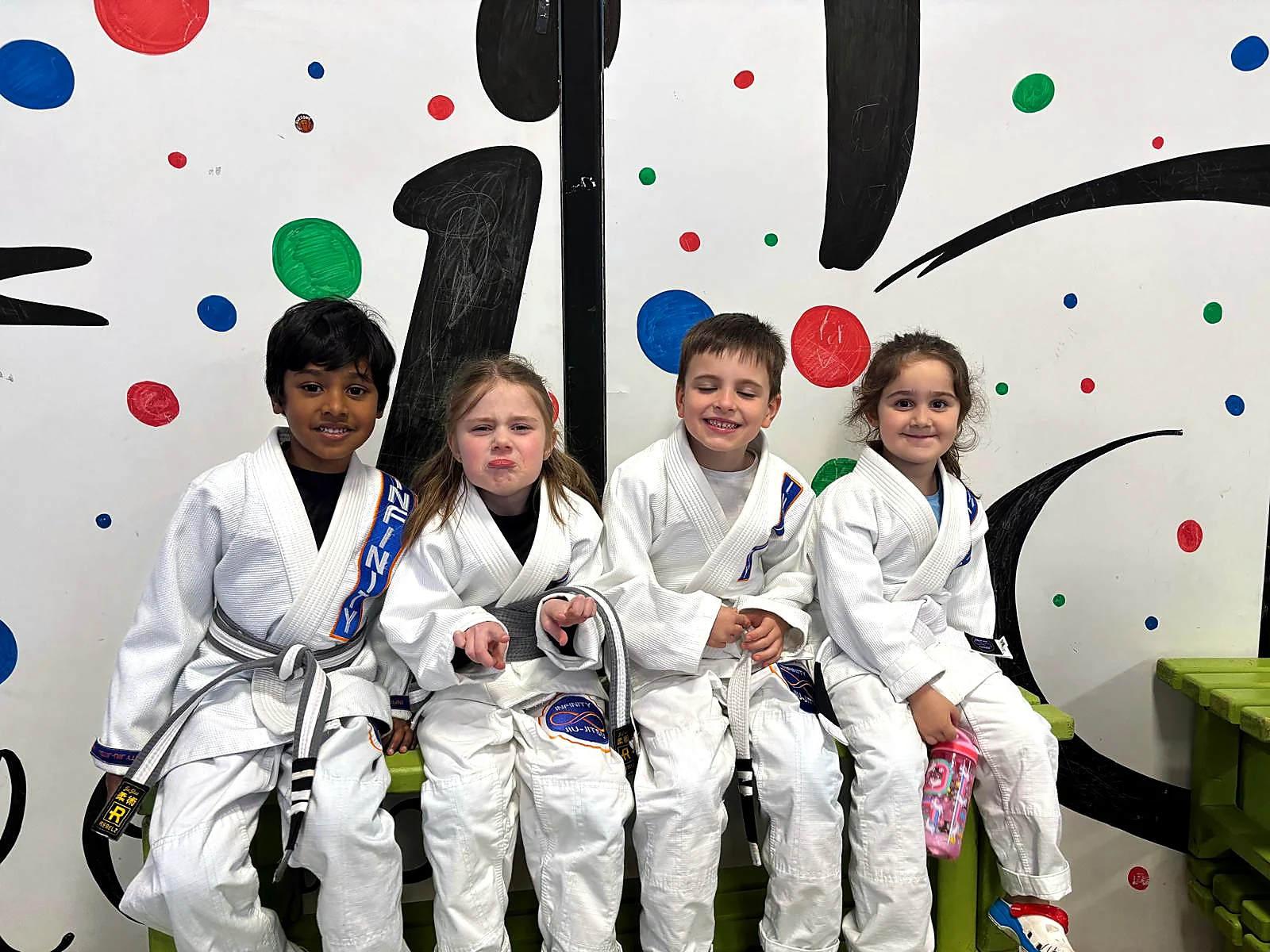 Two young children practising a Jiu-Jitsu grip on the mats in Little Champions